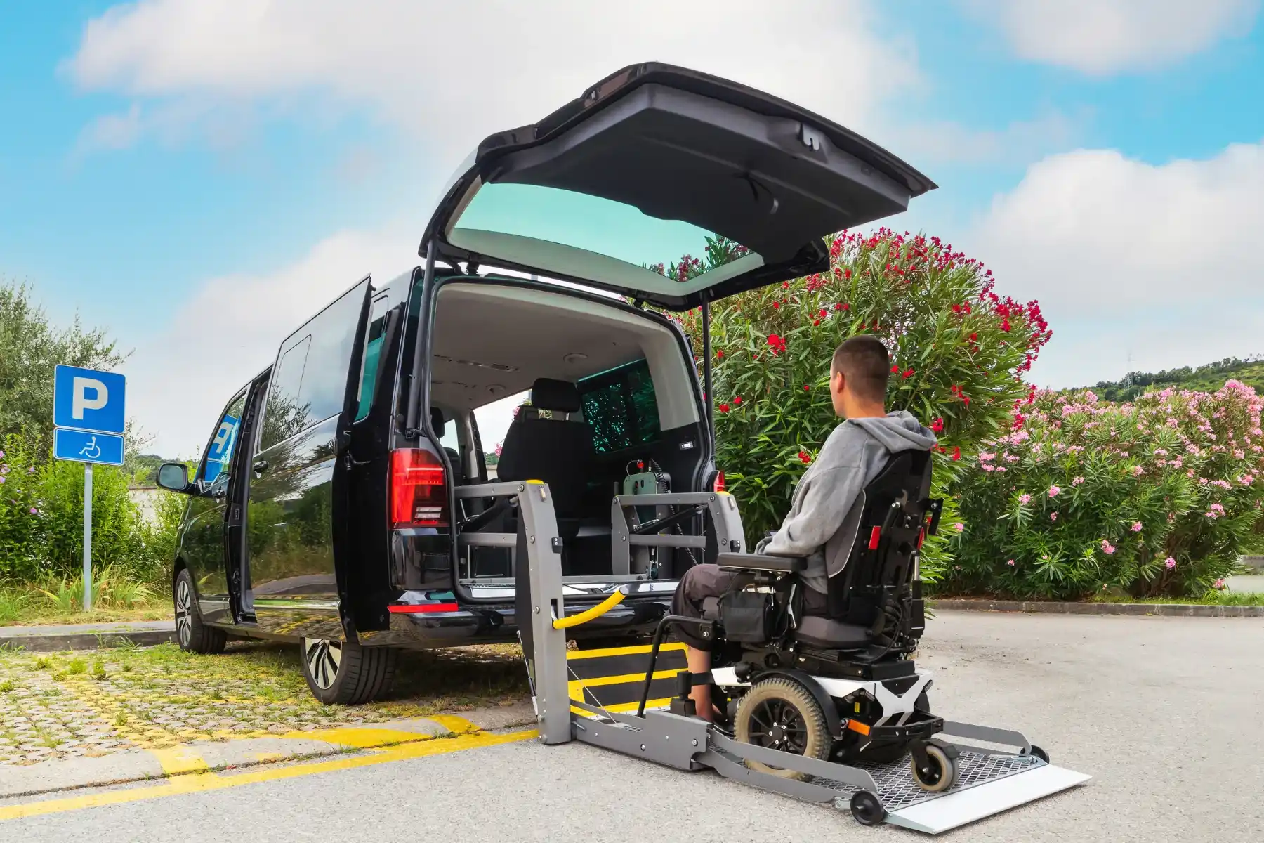 A person in a wheelchair uses a vehicle lift to enter for a convenient travel assistance