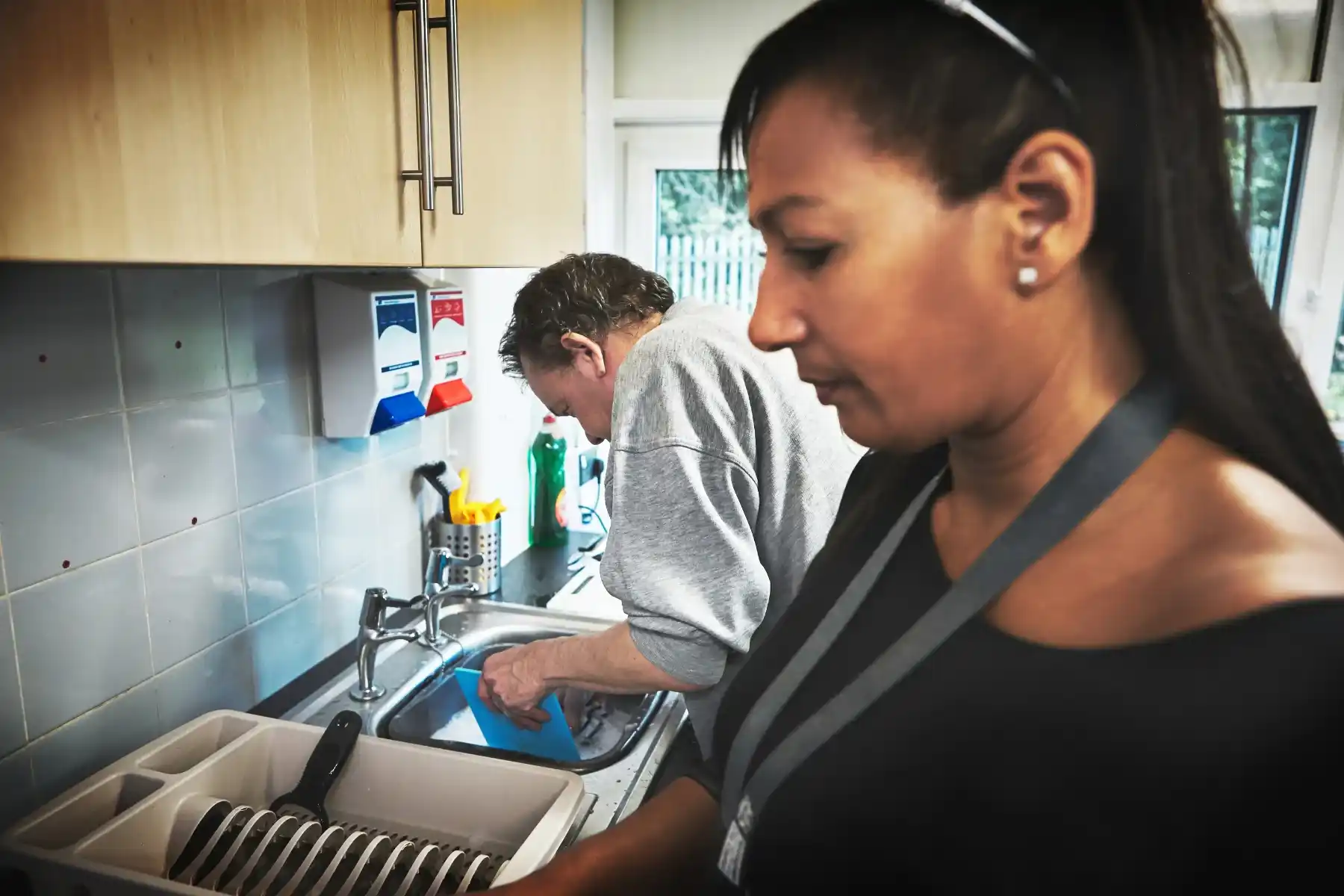 Support worker assisting a person with household cleaning