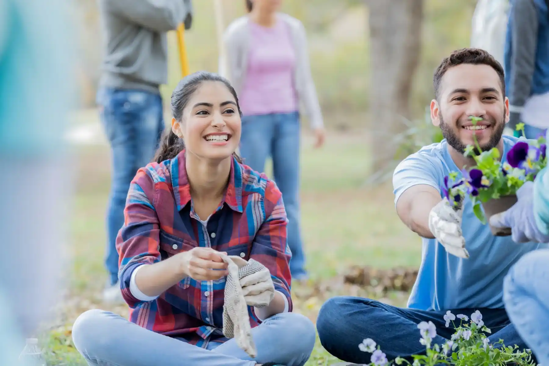 Smiling young adults participating in community gardening activity